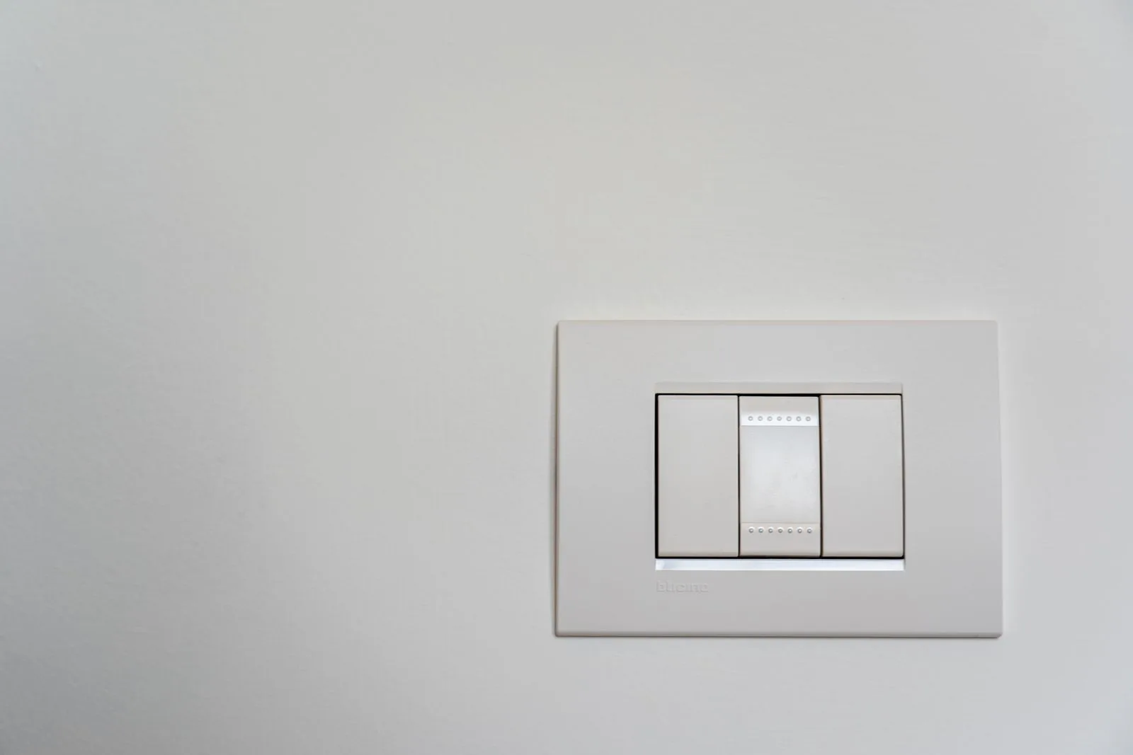 Moderner weißer Lichtschalter an einer hellen Wand